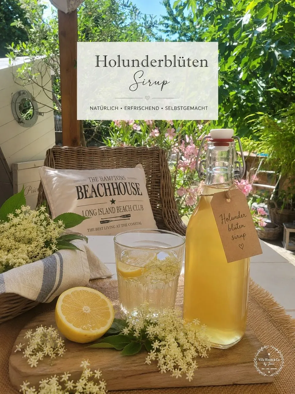 Elderflower cordial in a swing-top bottle with a kraft-paper tag, fresh elderflower umbels and lemons