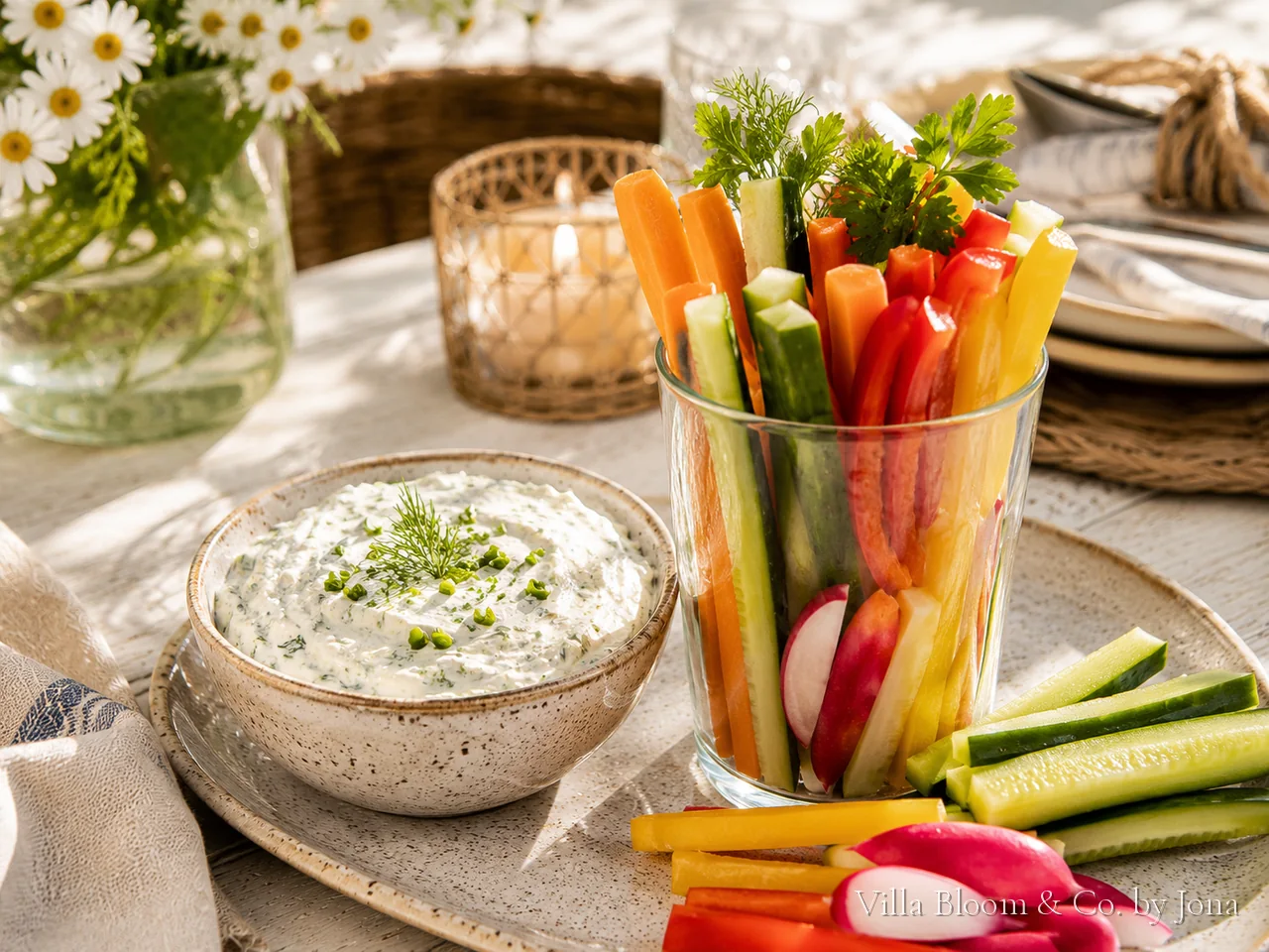 Cremiger Kräuterquark in einer Schale mit buntem Gemüse – Möhren, Gurke, Paprika und Radieschen als Sticks